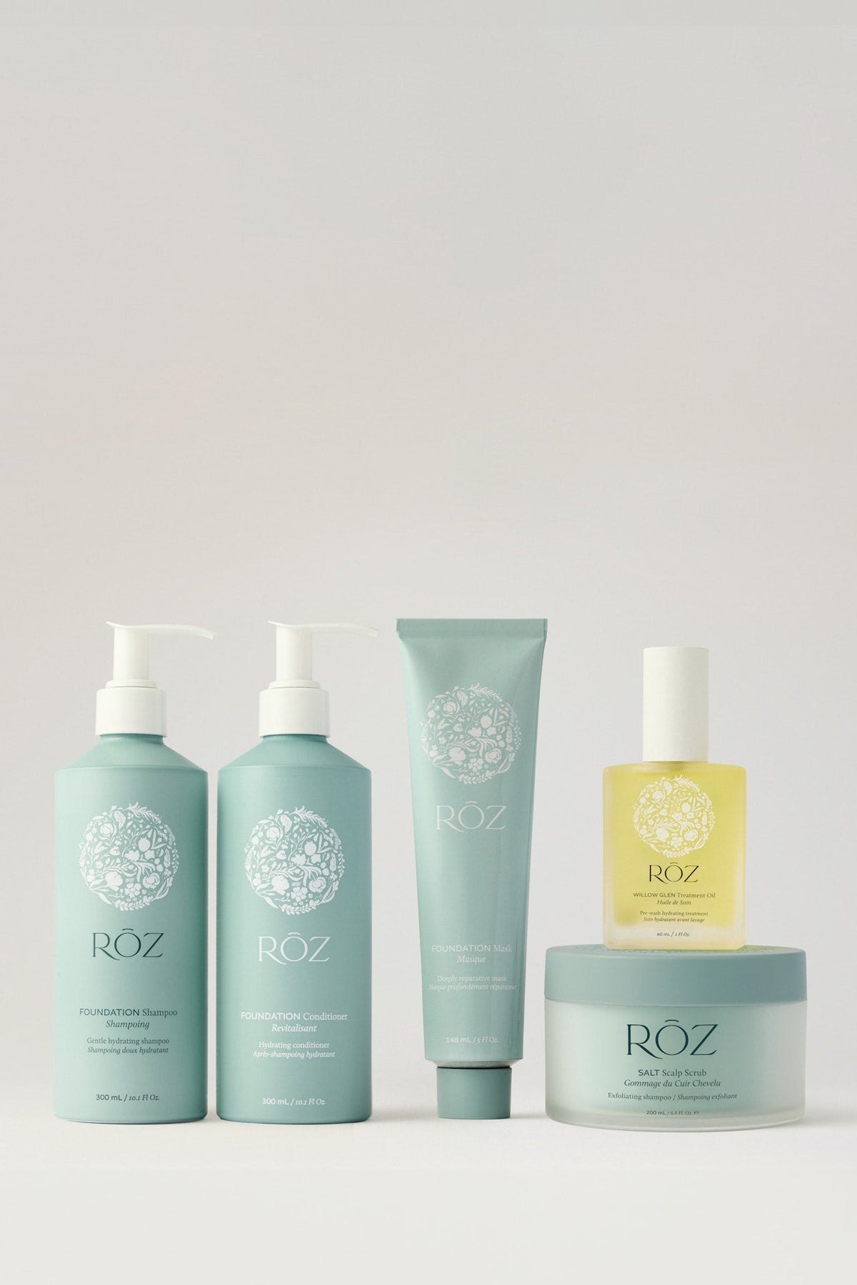 RŌZ wash-day products, including shampoo, conditioner, a hair oil and a jar of Salt Scalp Scrub, on a pale background.